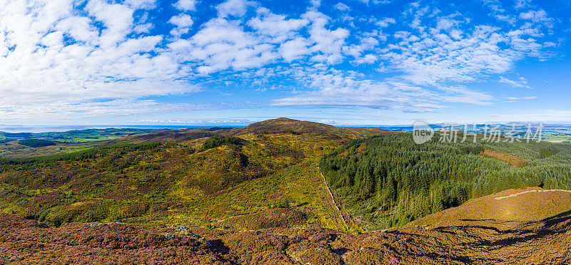 The aerial panoramic view of hills and forest in rural Dumfries and Galloway